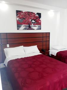 SangolquíHOTEL DEL RIVER MONUMENTO的一间卧室配有红色的床和红色毯子