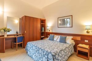 佛罗伦萨博尼法乔酒店的配有一张床和一张书桌的酒店客房