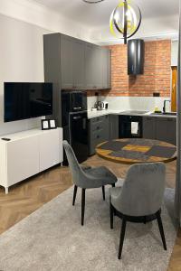 华沙Labo Apartment Metro Młociny的厨房配有桌子和两把椅子以及电视。