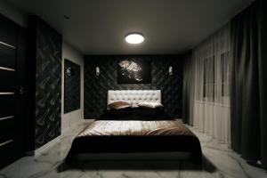 希卢泰Kiss Apartment的一间卧室配有一张黑色墙壁的床