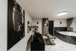 希卢泰Kiss Apartment的带浴缸的浴室和墙上的大画