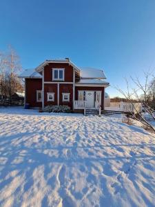 Röda villan的前面的红色房子,地面上有雪