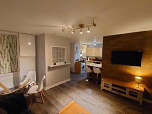因弗内斯The Black Isle Retreat的带沙发和电视的客厅以及厨房。