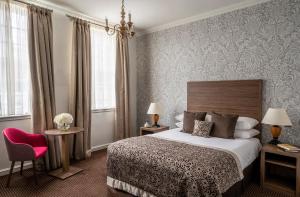 阿施精选布兰德萨奇广场酒店&SPA的酒店客房,配有一张床和一张红色椅子