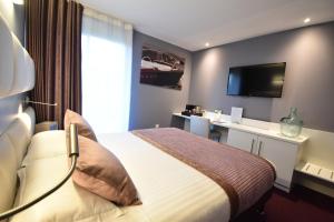 里摩日Hôtel du Golf Saint Lazare的一间酒店客房,配有一张床和一台电视