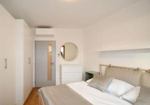 布尔诺EFI Residence Holzova 28的白色卧室配有床和镜子