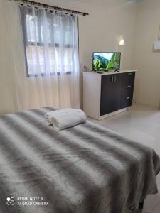 伊格雷日尼亚Casa Hermosa的一间卧室配有一张床和一台电视
