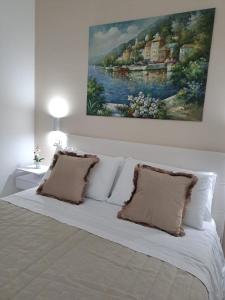 巴列塔Maison Riefolo的卧室配有一张白色床,墙上挂有绘画作品