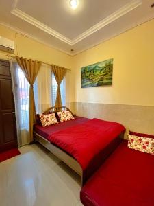 当格浪TAMA Guesthouse 15 People for Family or Group的一间卧室设有红色的床和窗户。