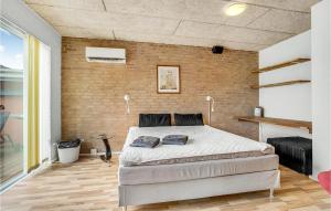 约灵1 Bedroom Amazing Apartment In Hjrring的一间卧室设有一张床和砖墙