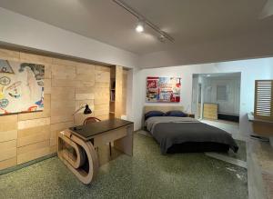 雅典Vouliagmeni Art Micro Loft的一间卧室配有一张床、一张书桌和一台电视。