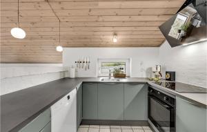 克利特默勒Nice Home In Thisted With Indoor Swimming Pool的厨房拥有白色的墙壁和木制天花板