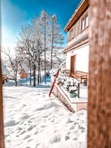 恰萨纳格拉Góralska Chata的一座有雪盖的院子,后面有一座房子