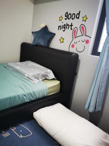吉隆坡Aishiteru Homestay的卧室配有一张床,墙上挂着晚安标志