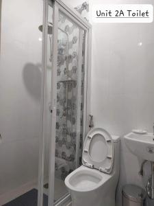 洛斯巴尼奥斯FLB Apartelle Los Banos的白色的浴室设有卫生间和淋浴。