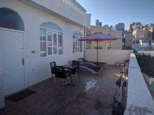 阿加迪尔amal's apart&studio的阳台的天井配有桌子和遮阳伞。