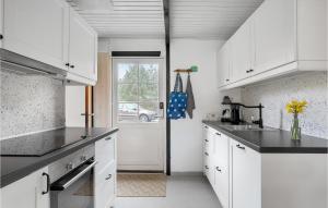 维斯特索马肯Stunning Home In Aakirkeby With Wifi的厨房配有白色橱柜和窗户。