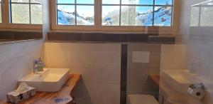东蒂罗尔地区马特赖彭吉兹尔豪夫公寓的一间带两个盥洗盆和窗户的浴室