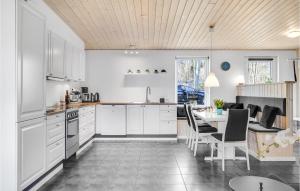 伦德Lovely Home In Rnde With Wifi的厨房配有白色橱柜和桌椅