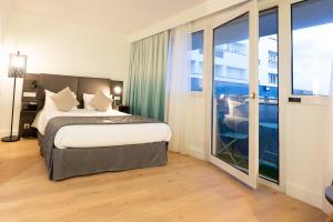 加来Holiday Inn Calais-Centre, an IHG Hotel的酒店客房设有一张床和一个大窗户