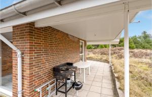 TagholmCozy Home In Rm With Kitchen的一个带砖墙和烧烤架的庭院