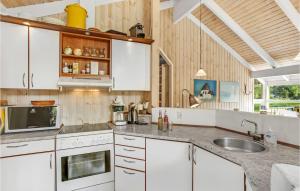 阿灵厄Beautiful Home In Allinge With 3 Bedrooms, Sauna And Wifi的厨房配有白色橱柜和水槽