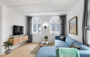 伦讷Amazing Apartment In Rnne With Wifi And 4 Bedrooms的客厅配有蓝色的沙发和电视
