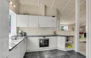 LøgstedNice Home In Lgstr With Wifi的厨房配有白色橱柜和台面