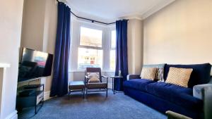 卡迪夫Moorland House by Switchback Stays的客厅设有蓝色的沙发和窗户。