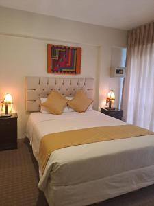 马丘比丘Real Excelencia的一间卧室配有一张大床和两盏灯