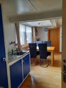 GaisVreni`s Ferienwohnung的厨房以及带桌子和蓝色椅子的用餐室。