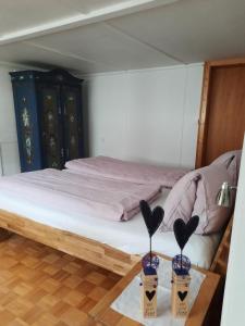 GaisVreni`s Ferienwohnung的一间卧室,配有一张桌子上的两瓶花床