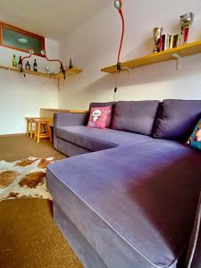 博格塔塞斯特雷Sestriere Borgata appartamento in montagna Casa di Bertu的客厅配有紫色沙发和桌子