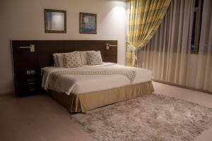 麦纳麦Butterfly Residence的一间卧室配有一张大床和地毯。