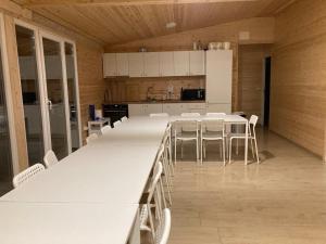 埃尔埃尼塔COMPLEX TURISTIC AVENTURA CAMP的大型厨房配有白色的桌子和白色的椅子