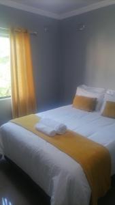 东伦敦Goshen Place的一间卧室配有两张带白色床单和黄色窗帘的床