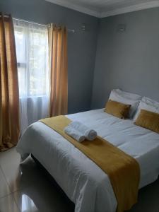 东伦敦Goshen Place的一间卧室配有一张床,上面有两条毛巾