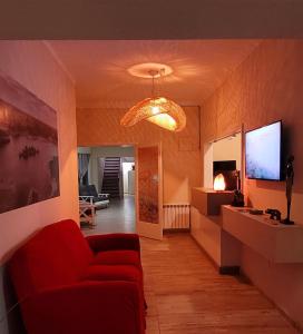 圣拉斐尔Privilegio Hostel的客厅配有红色沙发和电视