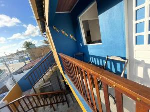 卡博迪圣阿戈斯蒂尼奥Casa na Orla - Praia de Gaibu!的蓝色的房子,阳台上设有木栏杆