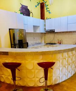 曼克拉Casa MANCORA的厨房配有带两个红色凳子的柜台