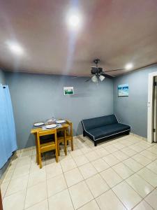 Six HutsBahia Azul Apartment的配有一张床和一张桌子及椅子的房间