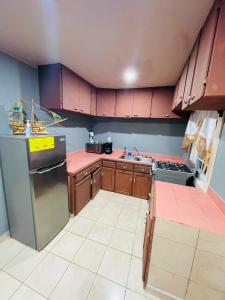 Six HutsBahia Azul Apartment的厨房配有木制橱柜和不锈钢冰箱。
