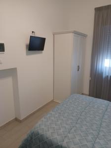 巴里哥斯达酒店的卧室配有一张床,墙上配有电视。