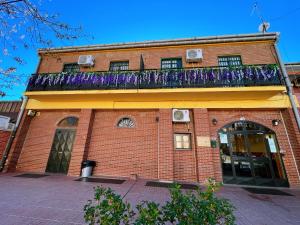 马德里Hostel Napoles的一座砖砌建筑,上面设有阳台
