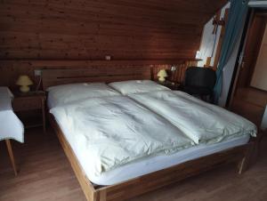 玛丽亚普法尔Haus Ferner-Lerchner的木墙客房内的一张大床