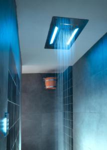 巴贝里诺·迪·穆杰罗Il Castelluccio Country Resort Restaurant & SPA的浴室的瓷砖墙壁上配有蓝色的灯光