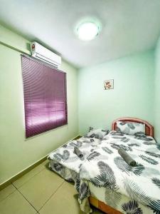东贡岸Cybercity Ph1 near KKIA by Family Homestay的一间卧室设有一张床和一个紫色的窗户