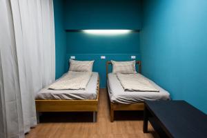 鱼池乡日月彩舟 日月潭背包客旅店 Sun Moon Lake Rainbow SUP Hostel的蓝色墙壁客房的两张床