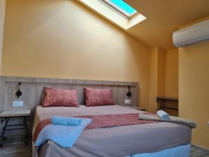 GostilitsaКомплекс Белла Терра的一间卧室配有一张带红色和蓝色枕头的大床