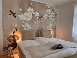 马尔尼茨Ankogel Lofts Mallnitz的卧室配有一张墙上鲜花的床
